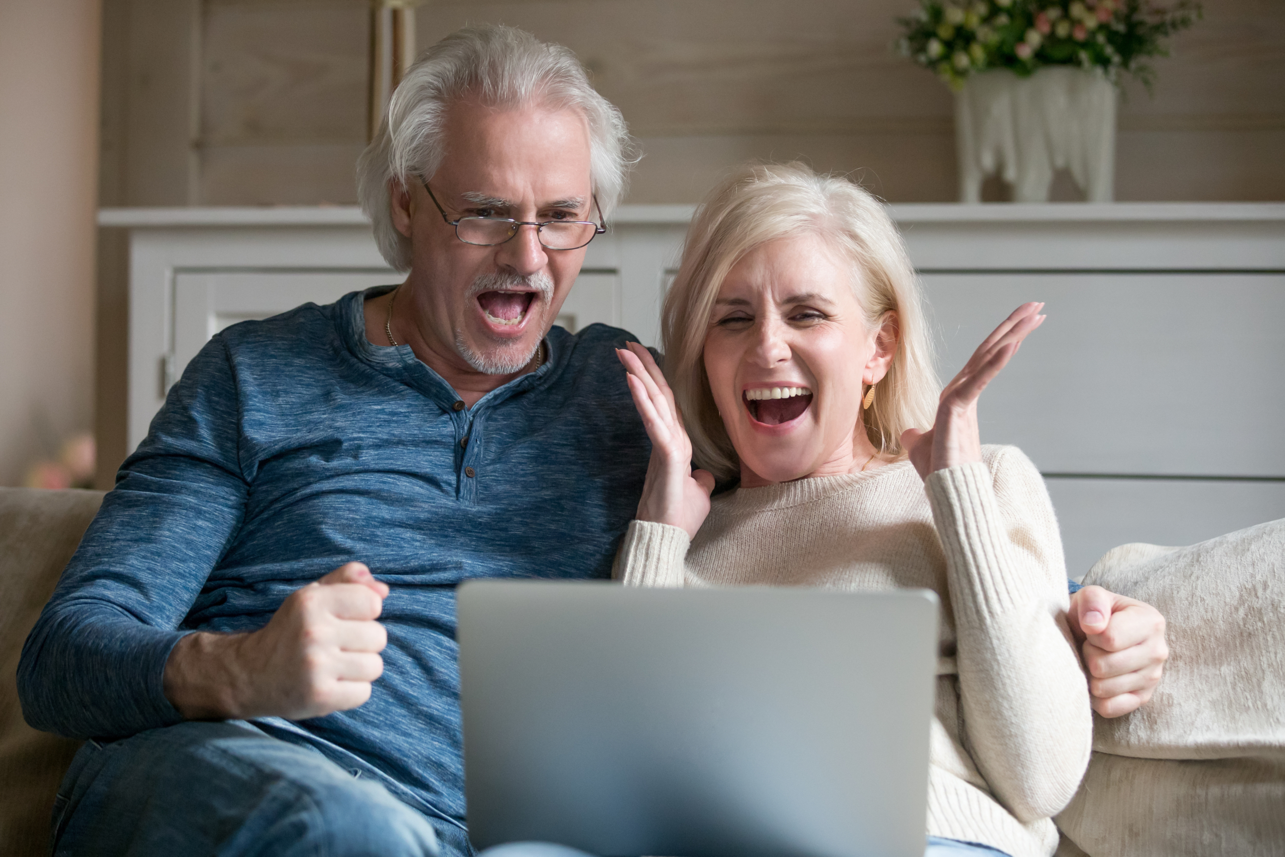 Excited senior couple screaming celebrating victory winning onli